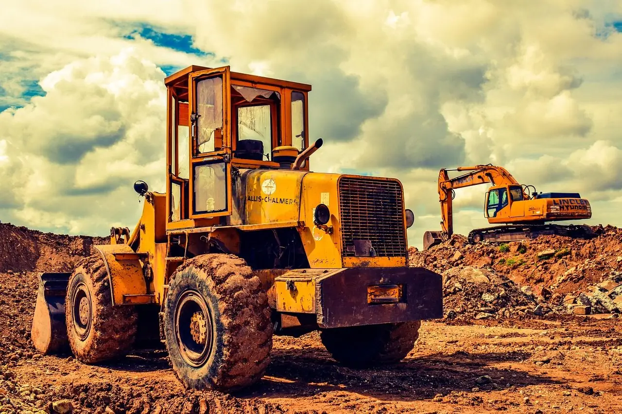Wheel loader and excavator working on a dirt construction site