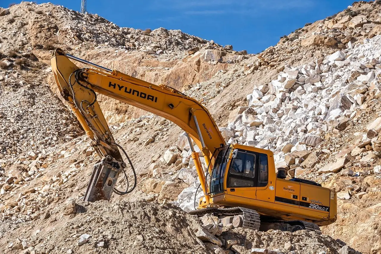 Excavator with a hydraulic breaker working in a rocky cut